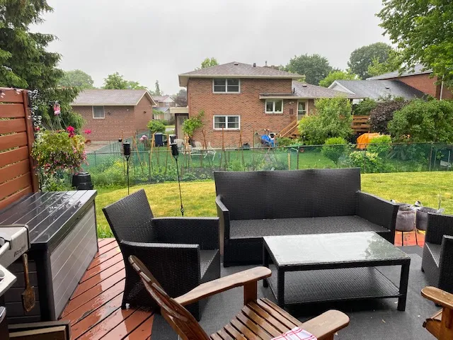 Covered backyard deck with outdoor furniture built by Land-Con Pools in Toronto